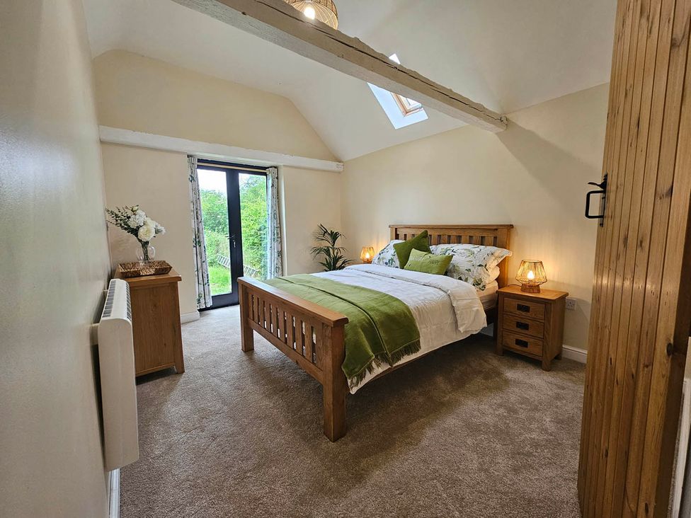 A bedroom with a bed and nightstands at Lily's Cottage Suffolk Sleeps 2 with Pets in Mendlesham Green near Stowmarket