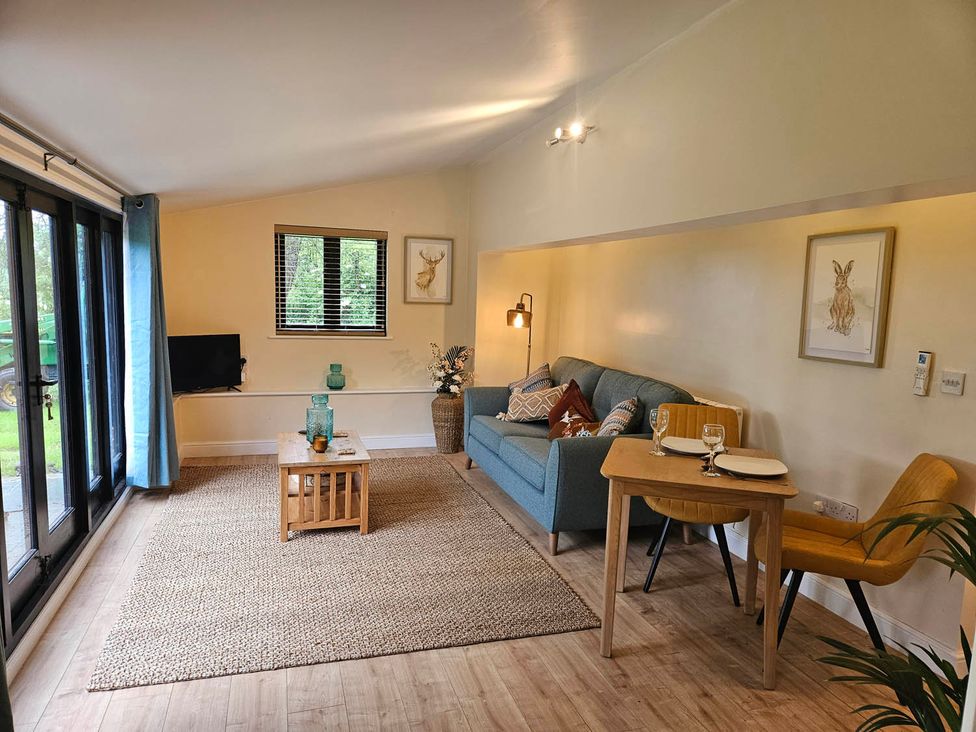 A living room with a sofa and dining table at Lily's Cottage Suffolk Sleeps 2 with Pets Mendlesham Green near Stowmarket
