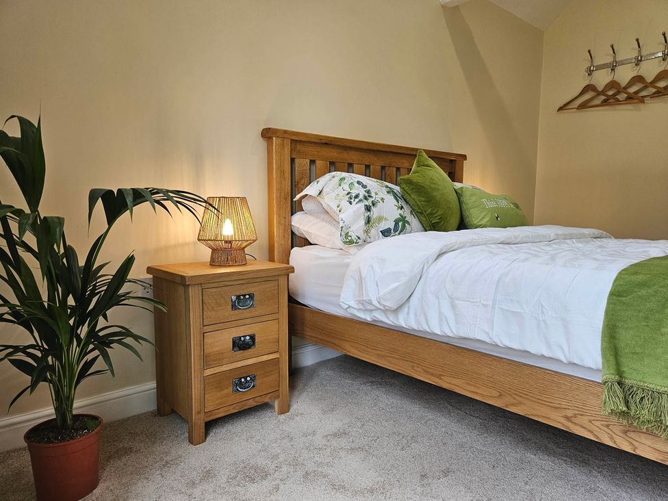 A bedroom with a bed, nightstand, plant and lamp at Lily's Cottage Suffolk Sleeps 2 with Pets in Mendlesham Green near Stowmarket