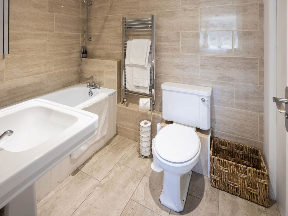 A bathroom with a bath, sink, toilet, and towel rail at The Dovecote 3Bed Cottage Rowden Manor Chippenham