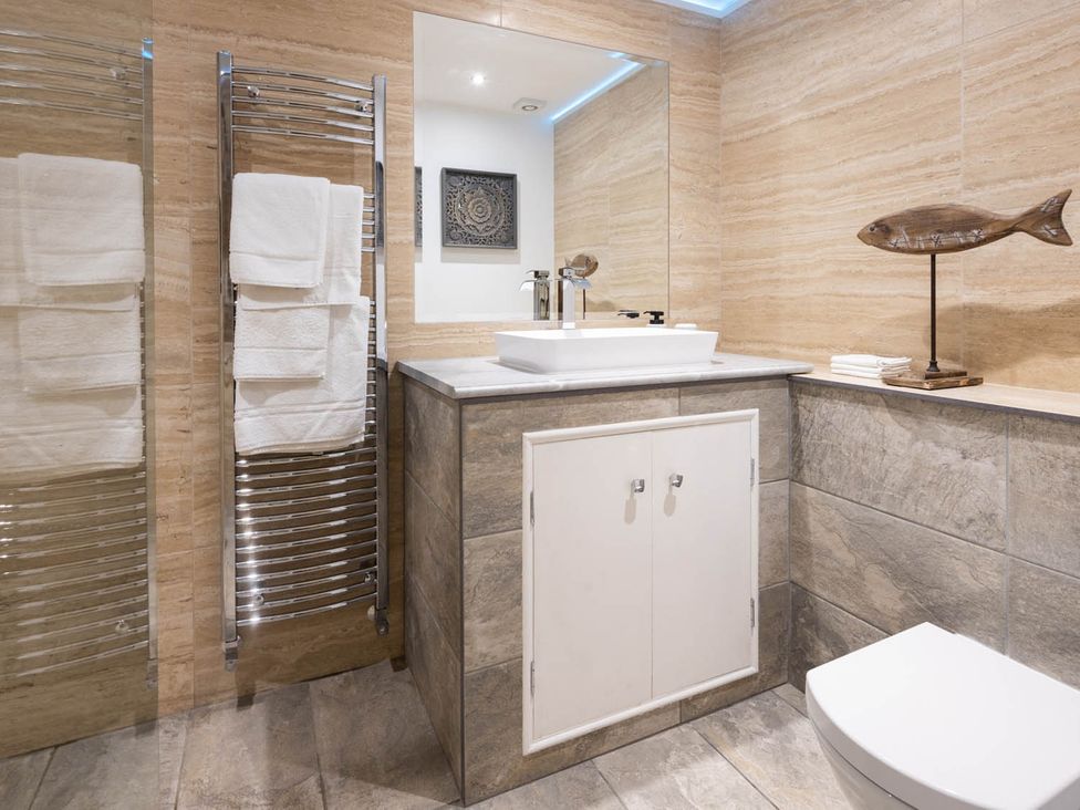 A bathroom with a sink, toilet, and towel rack at The Dovecote 3Bed Cottage Rowden Manor Chippenham