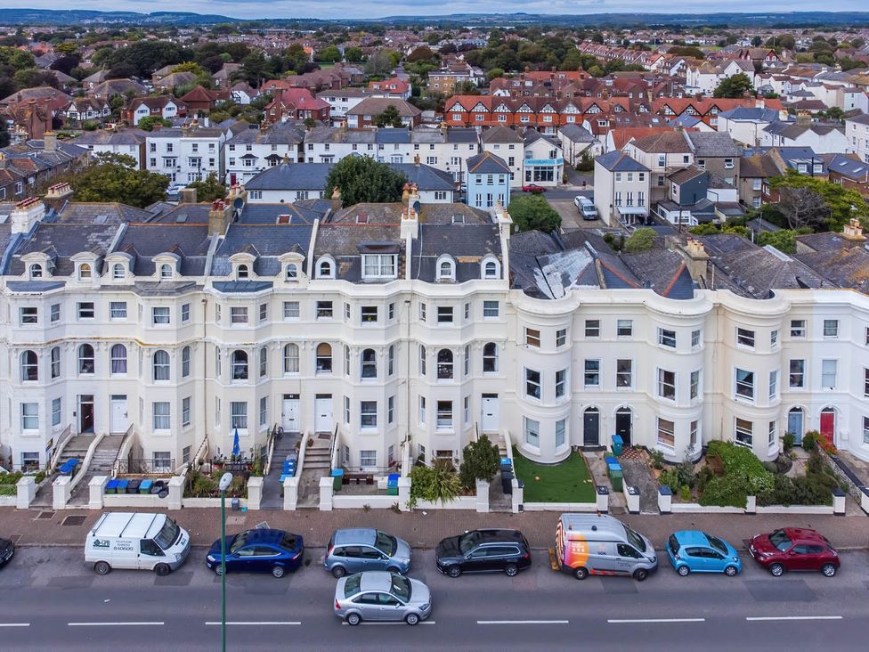 A row of houses with cars parked on the street at Seafront Apartment Private Garden Free Parking in Littlehampton