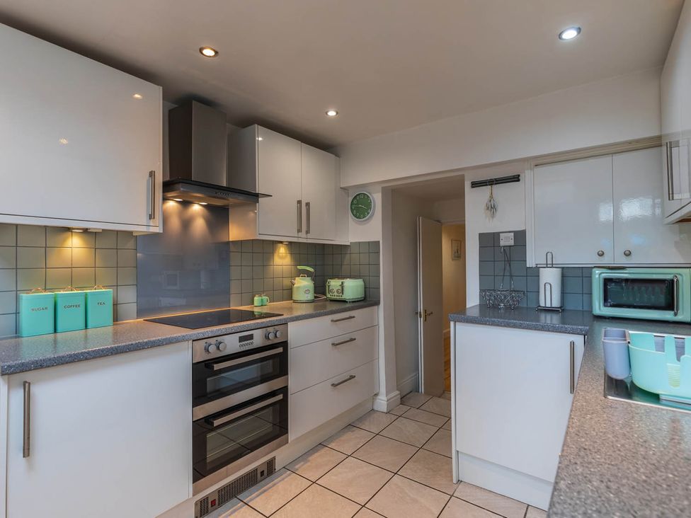 A kitchen with cabinets, stove, and microwave at Seafront Apartment Private Garden Free Parking Littlehampton