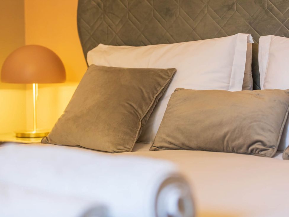 A bedroom with pillows and a lamp at Seafront Apartment Private Garden Free Parking in Littlehampton