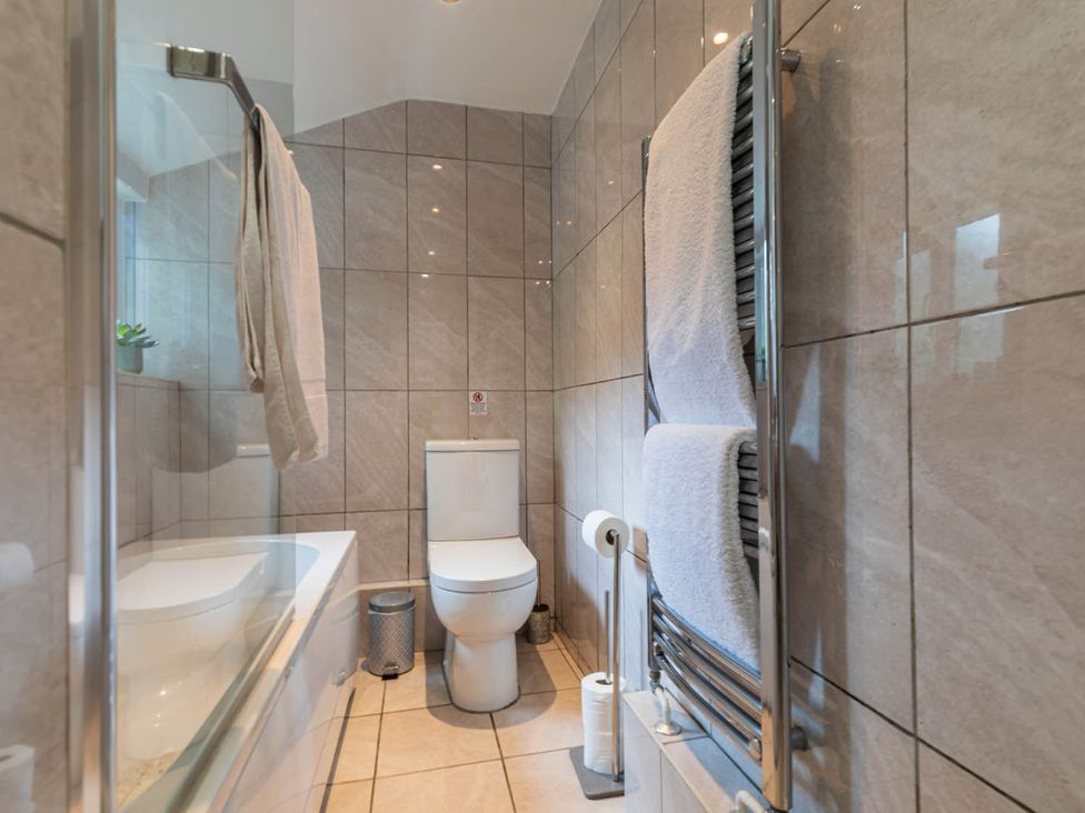 A bathroom with a bath tub and toilet at Seafront Apartment Private Garden Free Parking in Littlehampton