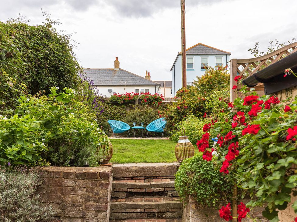 A garden with steps leading to chairs and a table at Seafront Apartment Private Garden Free Parking in Littlehampton