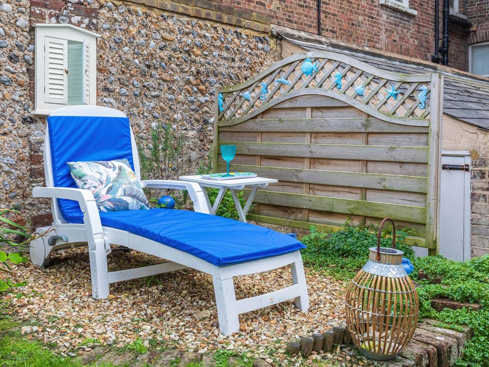 A garden area with a sun lounger and small table at Seafront Apartment Private Garden Free Parking in Littlehampton