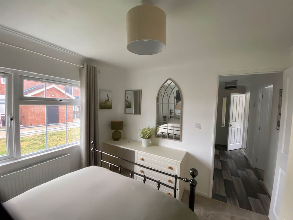 A bedroom with a bed and dresser at Paddock View Snetterton Norfolk near East Harling
