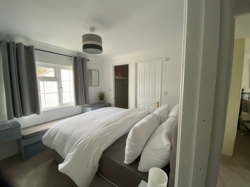 A bedroom with a bed and windows at Paddock View Snetterton Norfolk Near East Harling