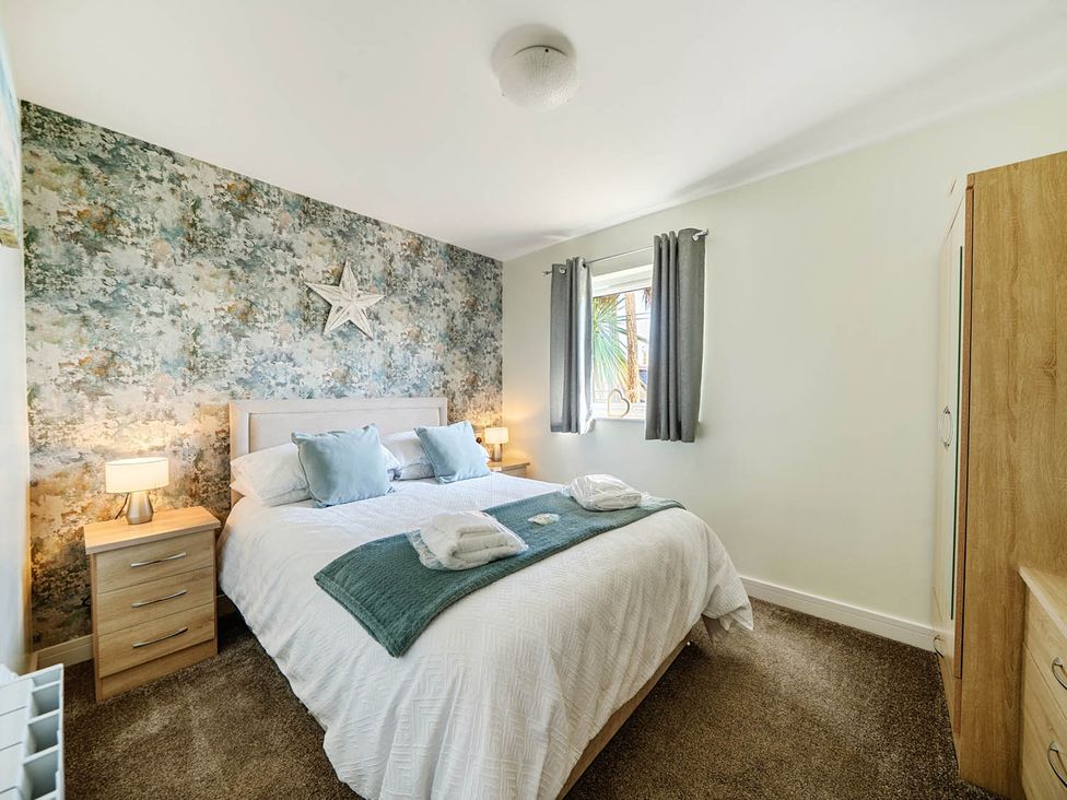 A bedroom with a bed and bedside tables at Seaside Chalet Retreat in Bridlington