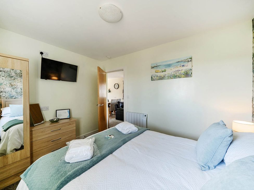 A bedroom with a bed and television at Seaside Chalet Retreat in Bridlington