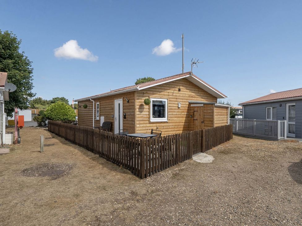 A cabin with a fenced area and outdoor seating at Seaside Chalet Retreat in Bridlington