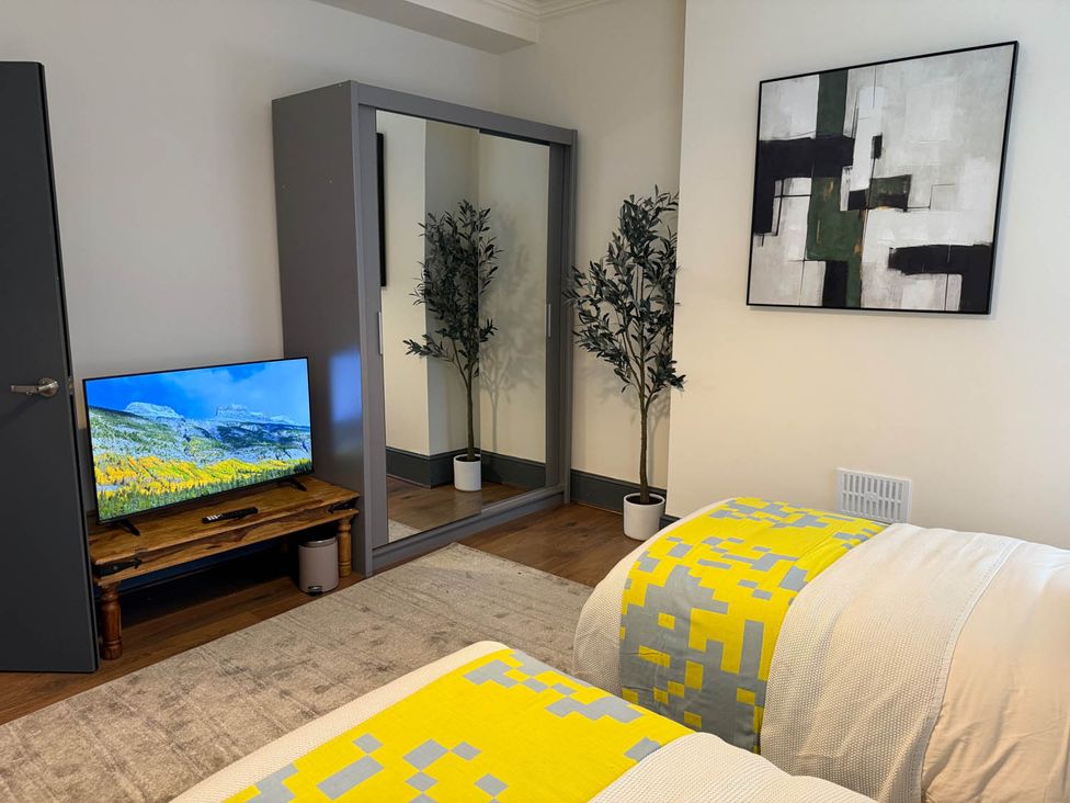 A bedroom with a television, mirror, and two beds at 3 Bedrooms in Central Tunbridge Wells Royal Tunbridge Wells