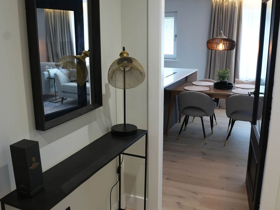 A hallway with a mirror and lamp leading to a dining area at 1st Floor Luxury 2Bed Apt Sleeps 6 St Andrews