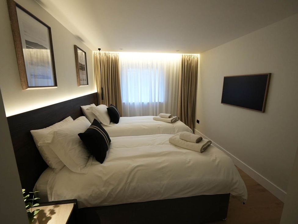 A bedroom with two beds and a window at 1st Floor Luxury 2Bed Apt Sleeps 6 in St Andrews
