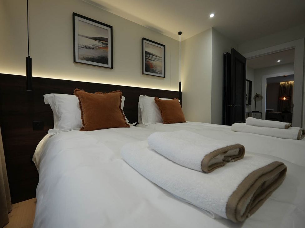 A bedroom with two beds and decorative pillows at 1st Floor Luxury 2Bed Apt Sleeps 6 St Andrews