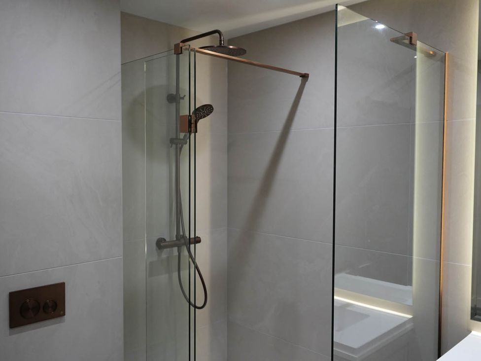 A shower area with glass panels and a shower head at 1st Floor Luxury 2Bed Apt Sleeps 6 St Andrews