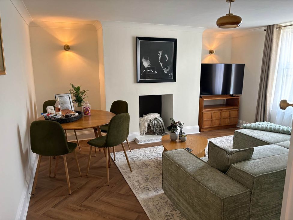 A living room with a table, chairs, sofa, and television at 1 Bed Sleeps 2 Near Beach Parking Hastings