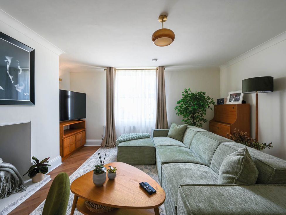 A living room with a sofa and television at 1 Bed Sleeps 2 Near Beach Parking Hastings