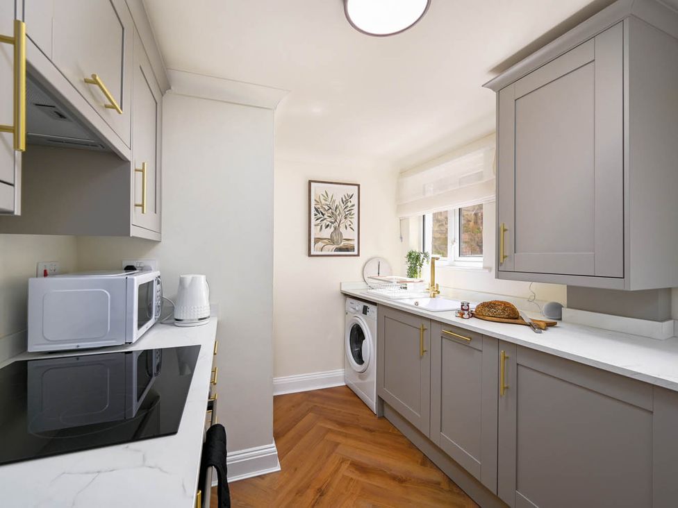 A kitchen with appliances and a washing machine at 1 Bed  Sleeps 2  Near Beach Parking in Hastings
