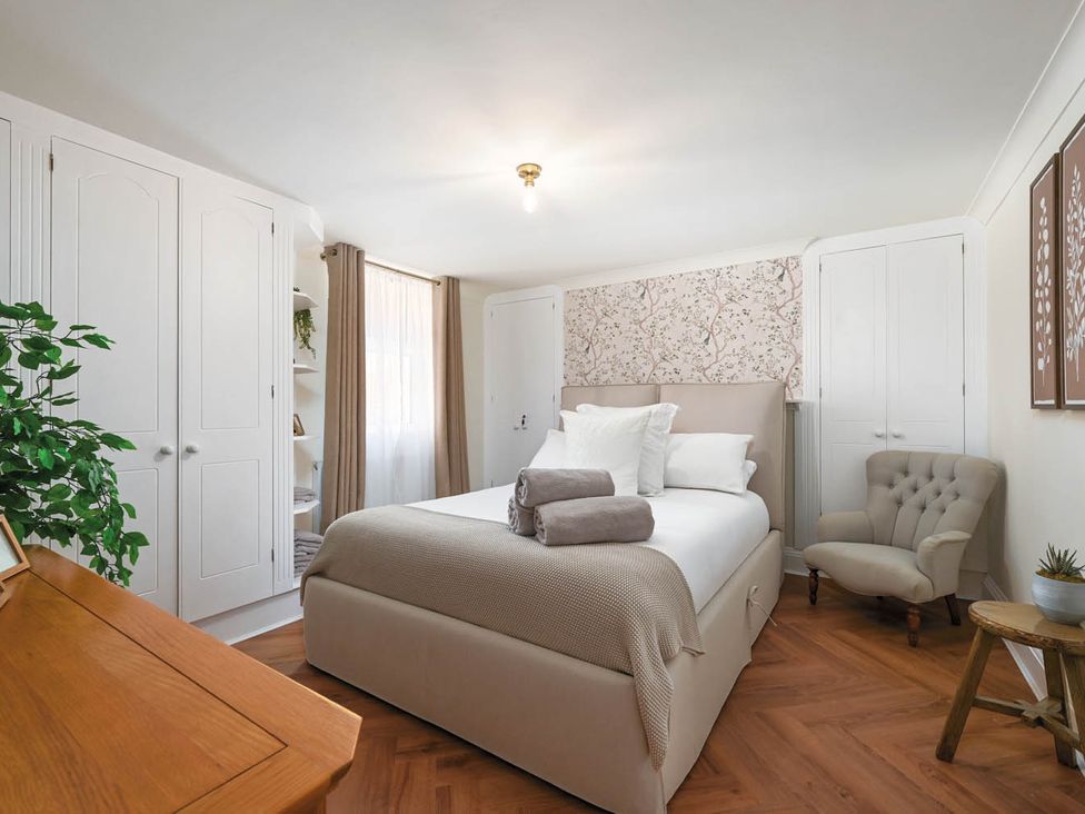 A bedroom with a bed, wardrobe, and chair at 1 Bed Sleeps 2 Near Beach Parking Hastings