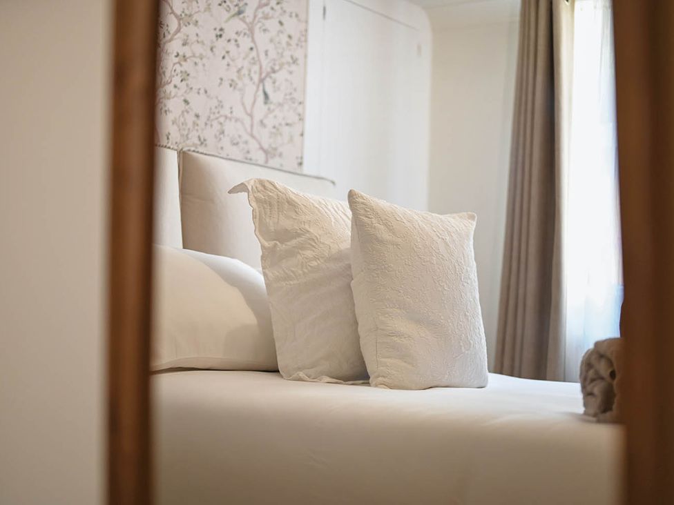 A bed with pillows and curtains in a bedroom at 1 Bed Sleeps 2 Near Beach Parking Hastings