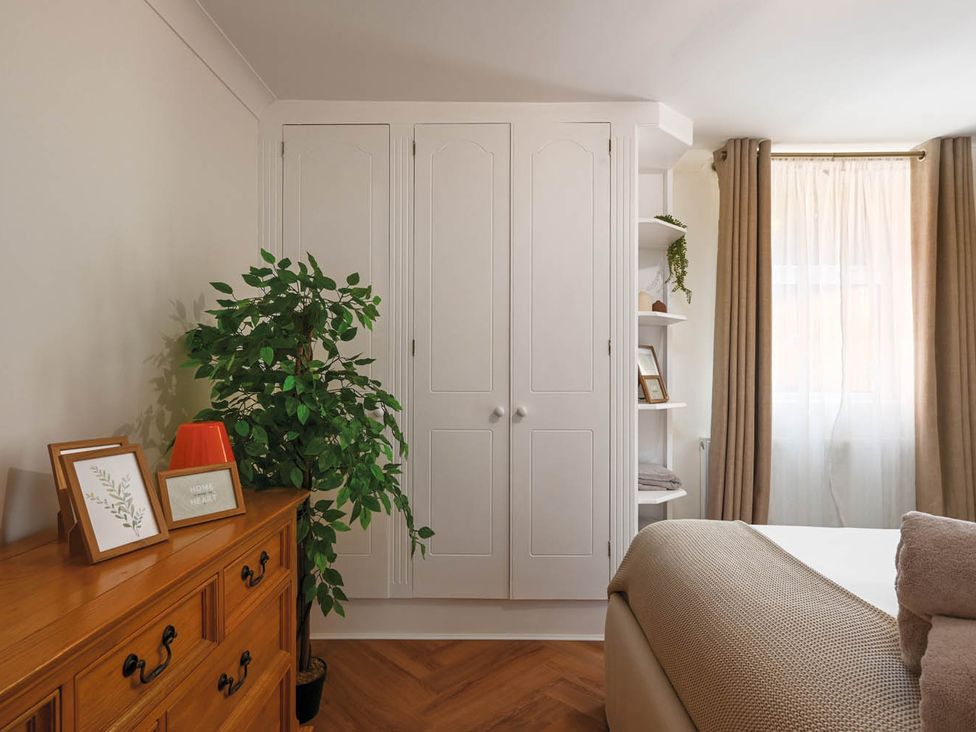 A bedroom with a cabinet, shelving, and a plant at 1 Bed Sleeps 2 Near Beach Parking in Hastings