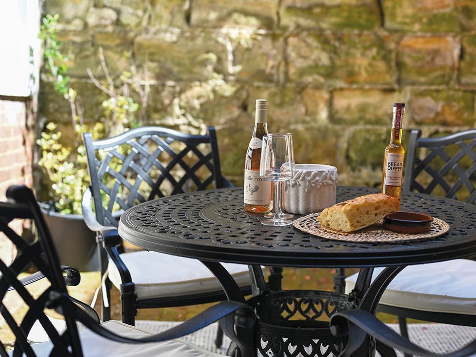 An outdoor seating area with a table and wine at 1 Bed Sleeps 2 Near Beach Parking Hastings