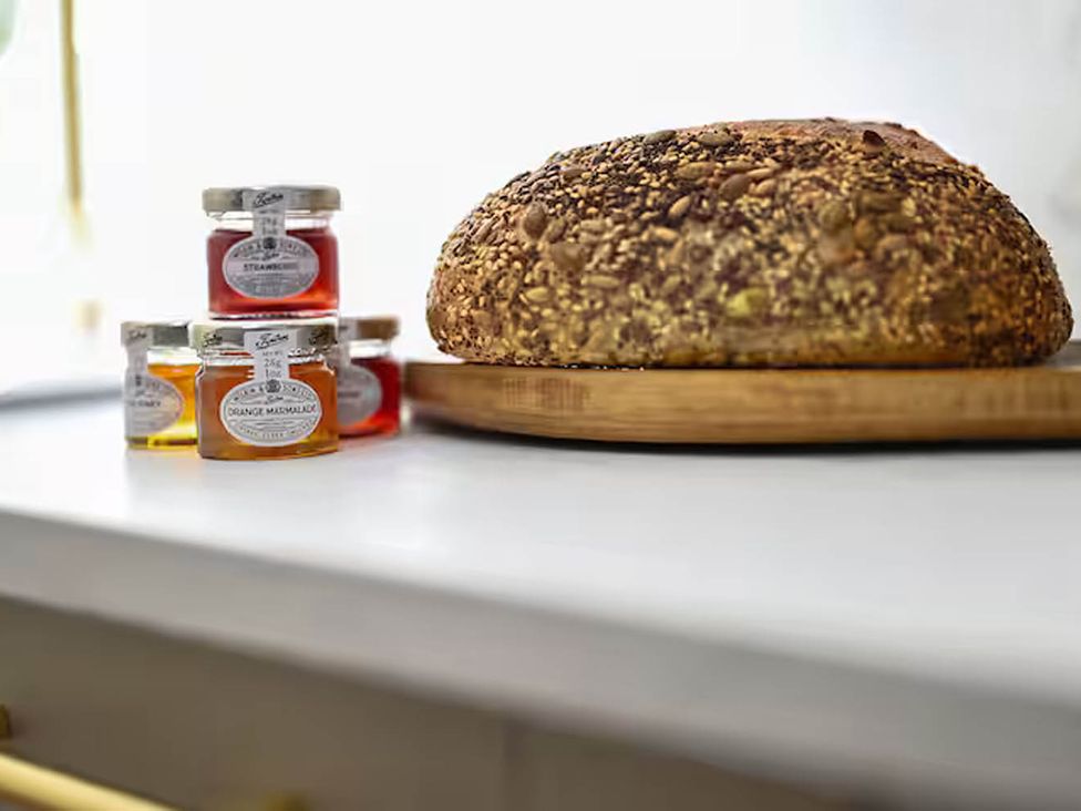 A kitchen counter with jam jars and a loaf of bread at 1 Bed Sleeps 2 Near Beach Parking Hastings
