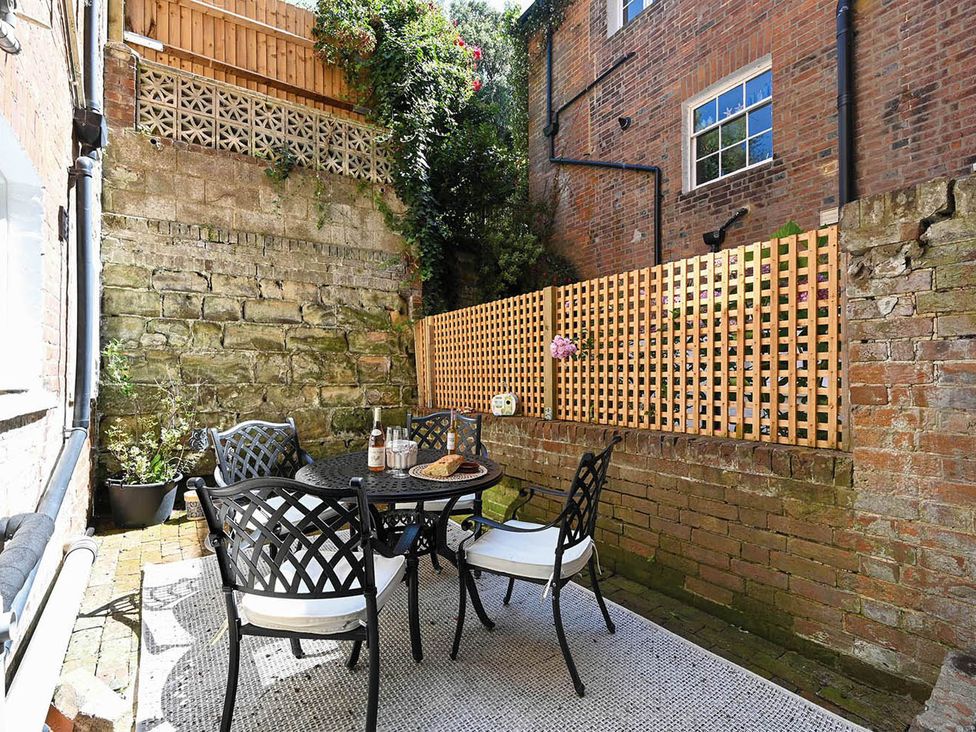 An outdoor patio with a table and chairs at 1 Bed Sleeps 2 Near Beach Parking Hastings