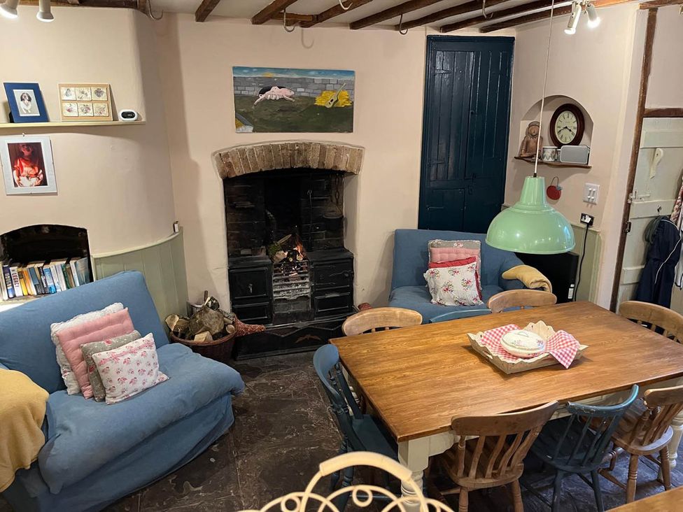 A living room with a fireplace and dining table at The Hills Farmhouse 6 Bed Sleeps 11 Pets Llanfilo near Talgarth