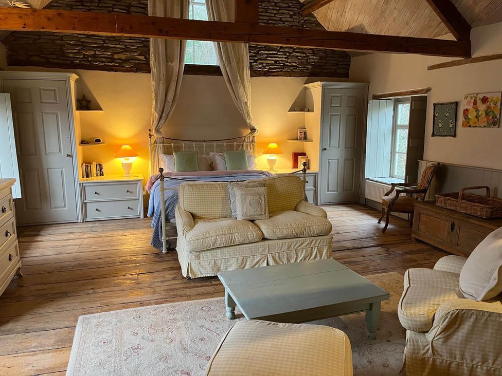 A bedroom with a bed and sofa at The Hills Farmhouse 6 Bed Sleeps 11 Pets in Llanfilo near Talgarth