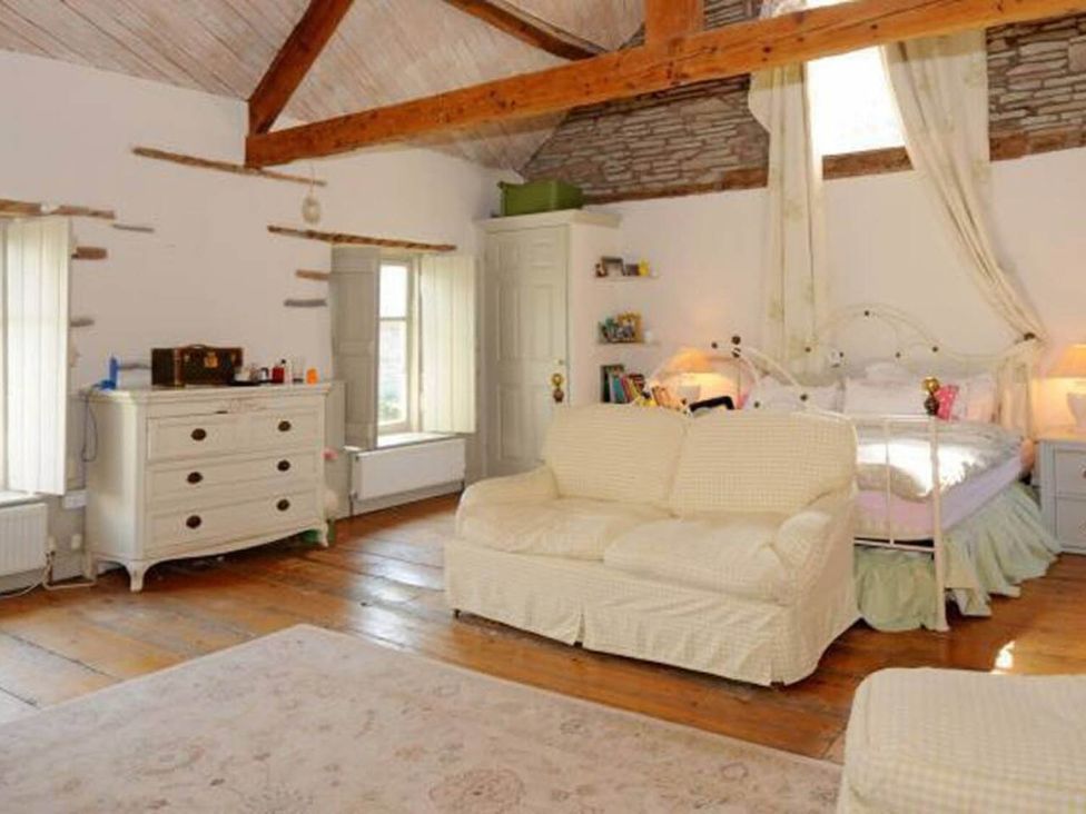 A bedroom with a bed and sofa at The Hills Farmhouse 6 Bed Sleeps 11 Pets Llanfilo near Talgarth