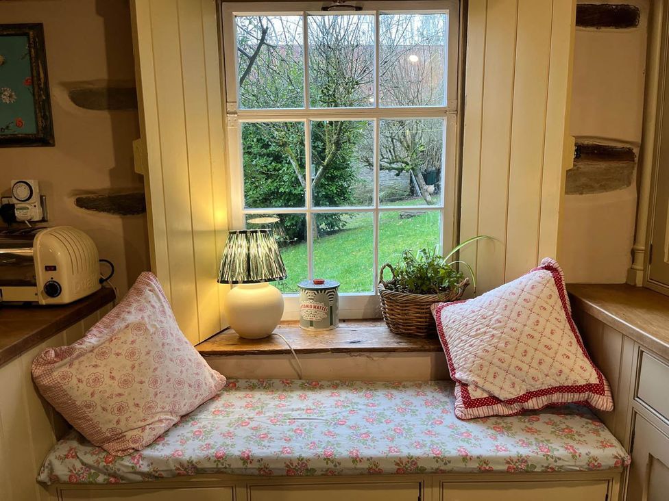 A kitchen window with cushions and a lamp at The Hills Farmhouse 6 Bed Sleeps 11 Pets Llanfilo near Talgarth