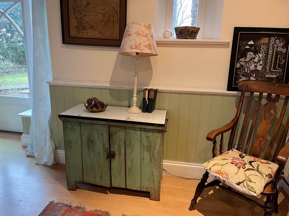 A living room with a green cabinet and a rocking chair at The Hills Farmhouse 6 Bed Sleeps 11 Pets Llanfilo near Talgarth