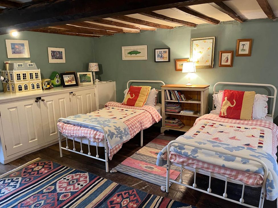 A bedroom with two beds and a bookshelf at The Hills Farmhouse 6 Bed Sleeps 11 Pets Llanfilo near Talgarth