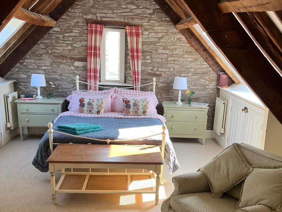 A bedroom with a bed and side tables at The Hills Farmhouse 6 Bed Sleeps 11 Pets in Llanfilo near Talgarth