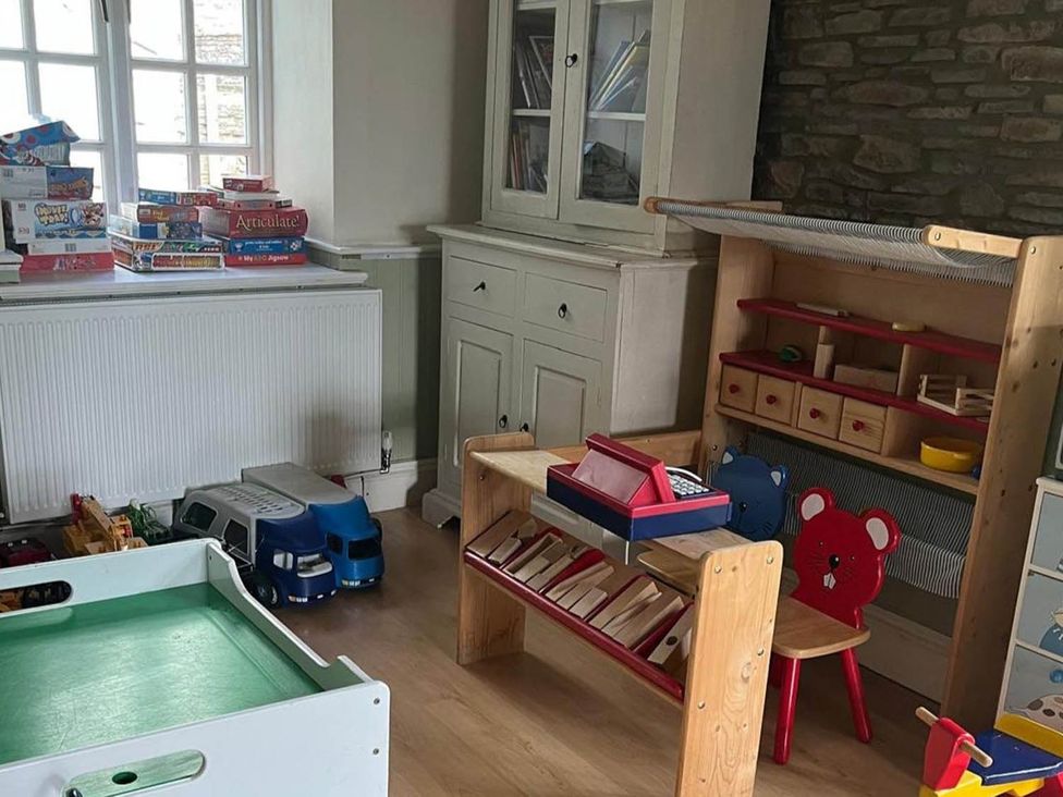 A playroom with toys and a shelf at The Hills Farmhouse 6 Bed Sleeps 11 Pets Llanfilo near Talgarth