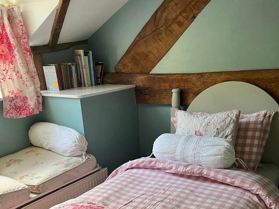 A bedroom with a bed, bookshelf, and pillows at The Hills Farmhouse 6 Bed Sleeps 11 Pets Llanfilo near Talgarth
