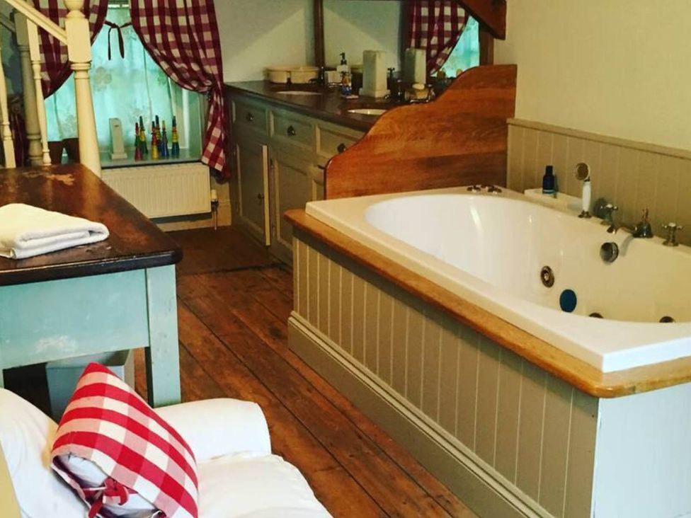 A bathroom with a bathtub and sink at The Hills Farmhouse 6 Bed Sleeps 11 Pets in Llanfilo near Talgarth