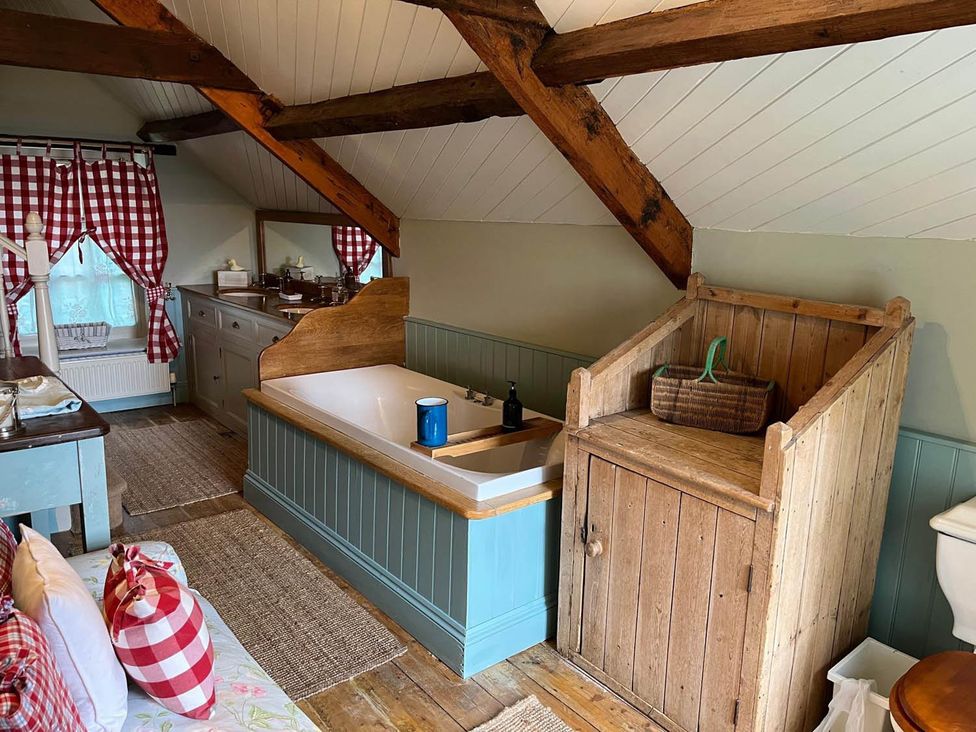 A bathroom with a bathtub and sink at The Hills Farmhouse 6 Bed Sleeps 11 Pets, Llanfilo near Talgarth