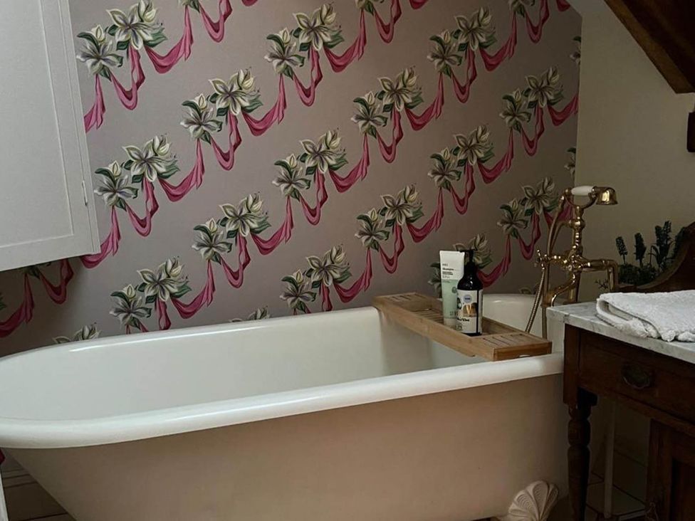 A bathroom with a freestanding bathtub and wall decoration at The Hills Farmhouse 6 Bed Sleeps 11 Pets, Llanfilo near Talgarth