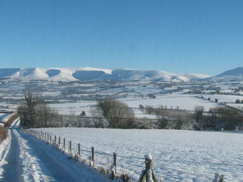 A snowy landscape with mountains and a road at The Hills Farmhouse 6 Bed Sleeps 11 Pets in Llanfilo near Talgarth