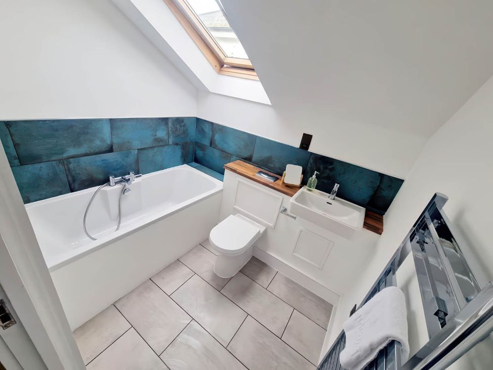 A bathroom with a bathtub, toilet, and sink at Apartment Sleeps 4 with Balcony and Parking in Kingsbridge
