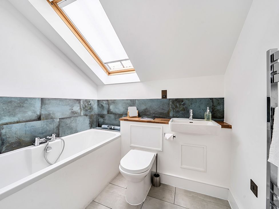 A bathroom with bathtub, toilet, and sink at Apartment Sleeps 4 with Balcony and Parking in Kingsbridge