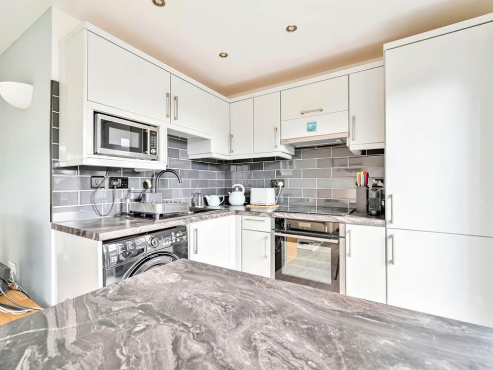 A kitchen with appliances and cabinets at Torpoint Apartment Sleeps4 Seaside Parking Downderry