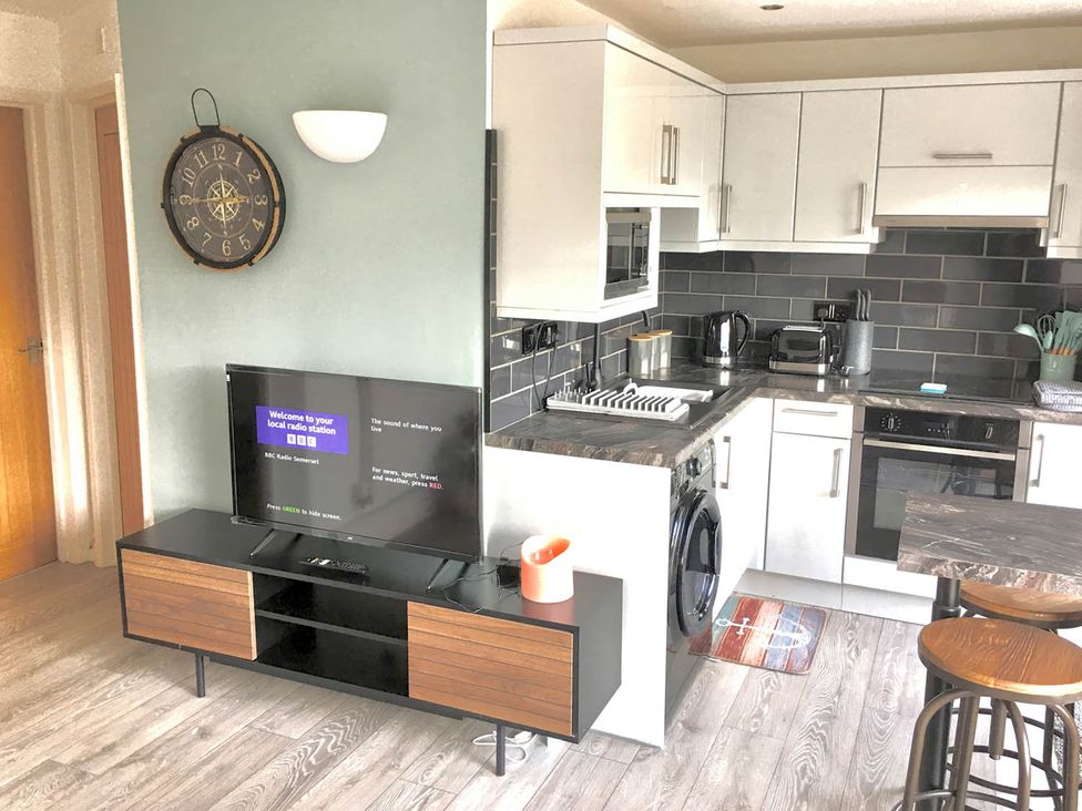 A kitchen with appliances and seating at Torpoint Apartment Sleeps4 Seaside Parking in Downderry