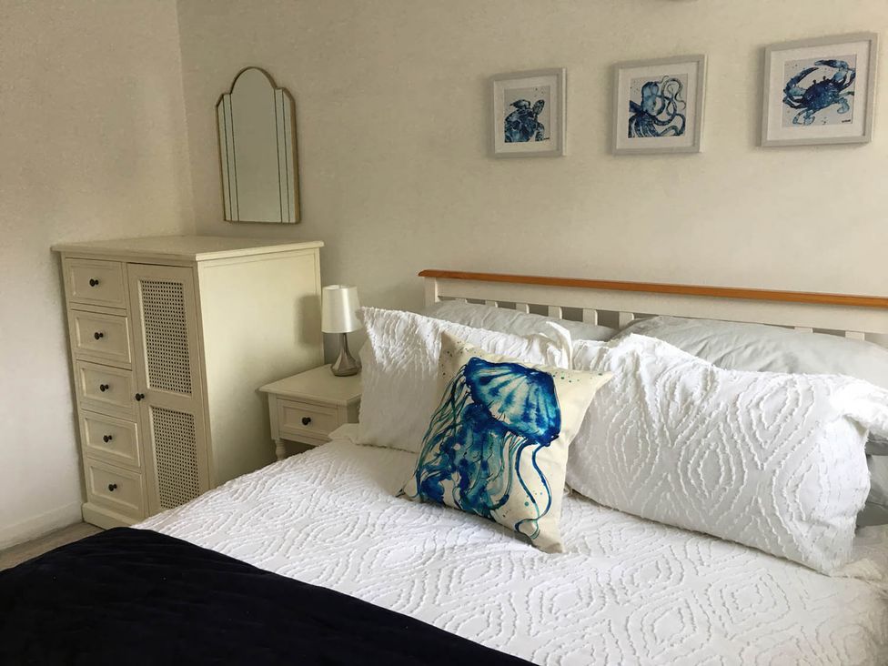 A bedroom with a bed and artwork on the wall at Torpoint Apartment Sleeps4 Seaside Parking in Downderry