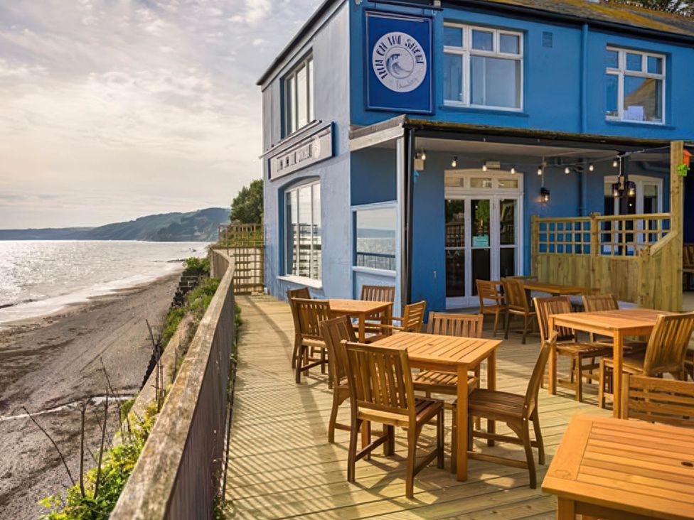 An outdoor seating area with tables and chairs at Torpoint Apartment Sleeps4 Seaside Parking in Downderry
