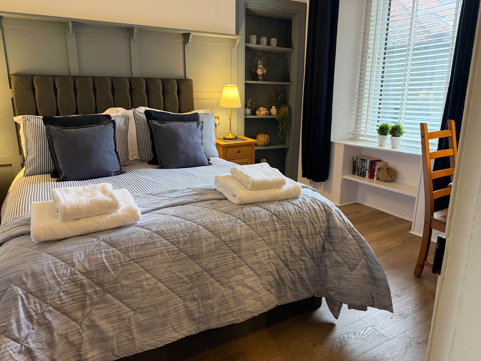 A bedroom with a bed and books on a shelf at Seaview Apartment 2Bed on Anstruther Harbour Anstruther